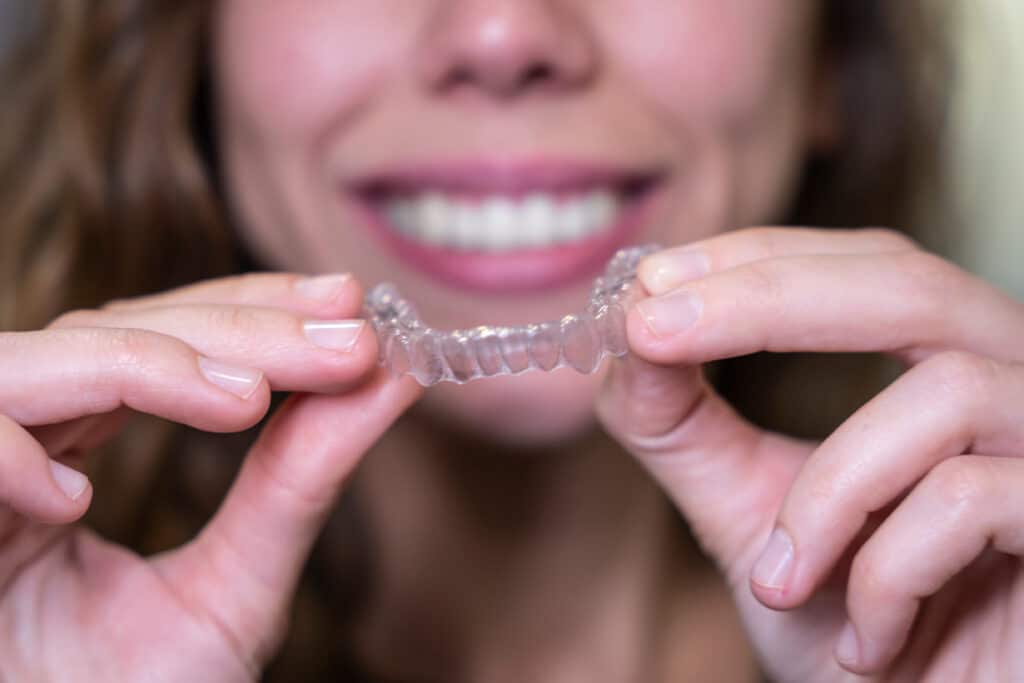 Woman holding Invisalign aligners at Palm Valley Orthodontics Scottsdale